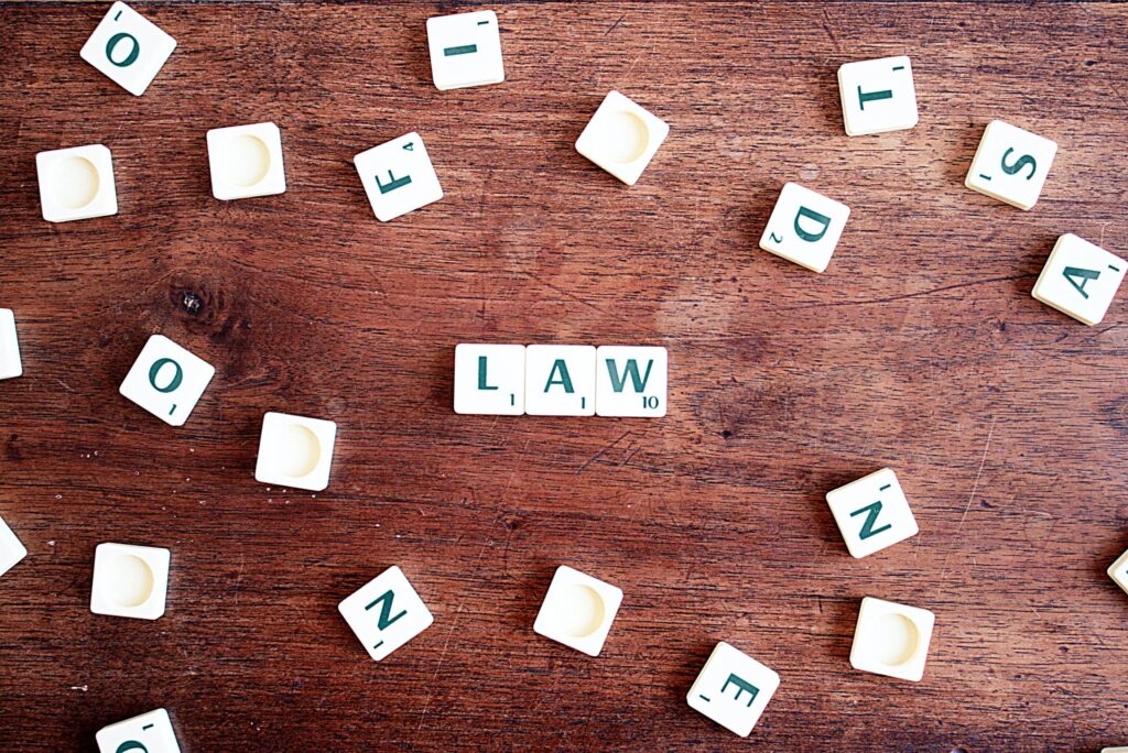 Scrabble letters against wooden background spelling 'law'