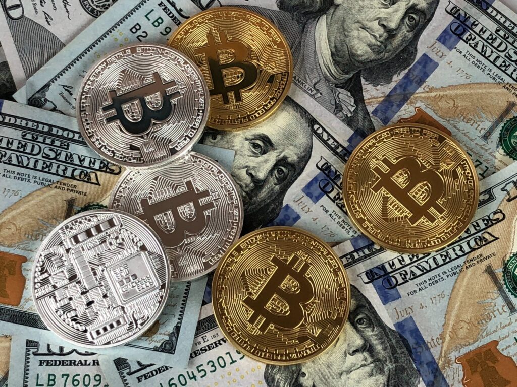 Gold bitcoin coins and dollar bills