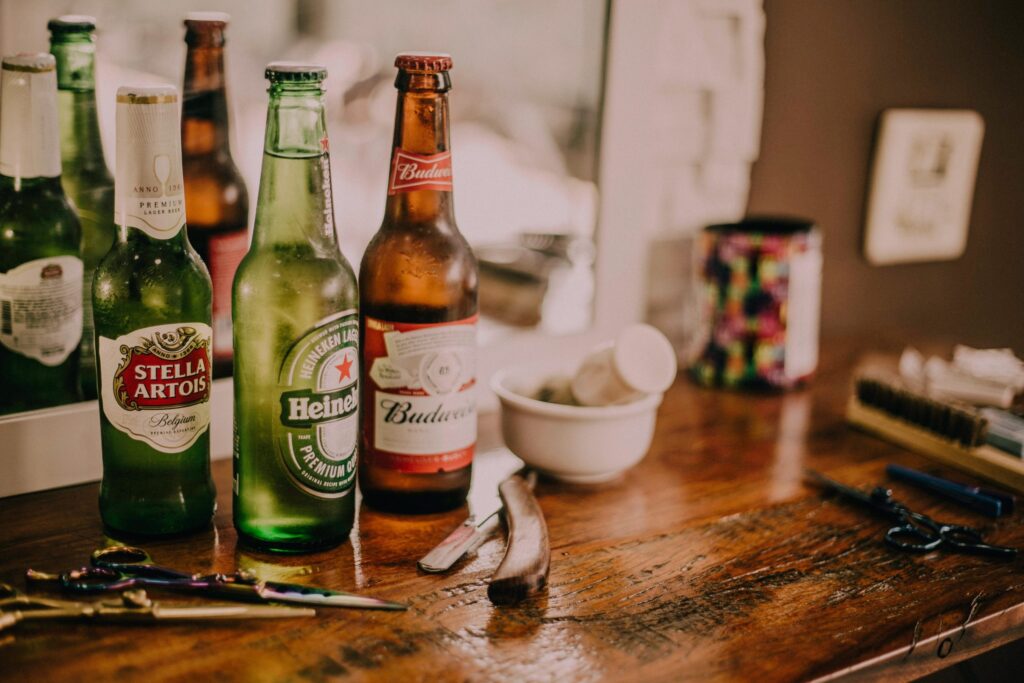 Assortment of beer bottles on wooden counter with scissors