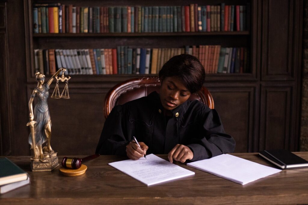 Woman judge signing documents in front of bookcase