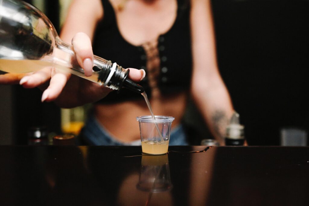 Woman pouring shot of liquor into shot glass