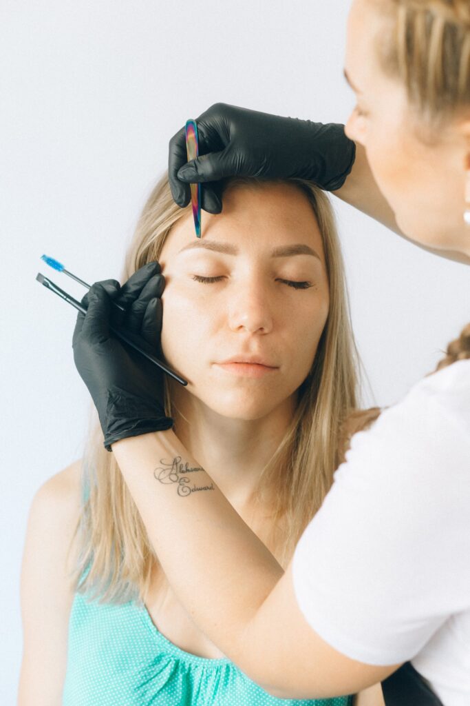 Makeup artist sculpting eyebrow on client
