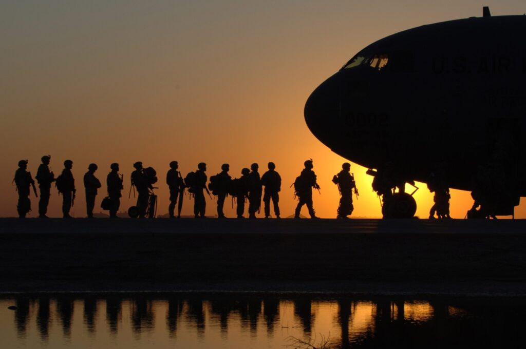 Silhouette of soldiers boarding a plane