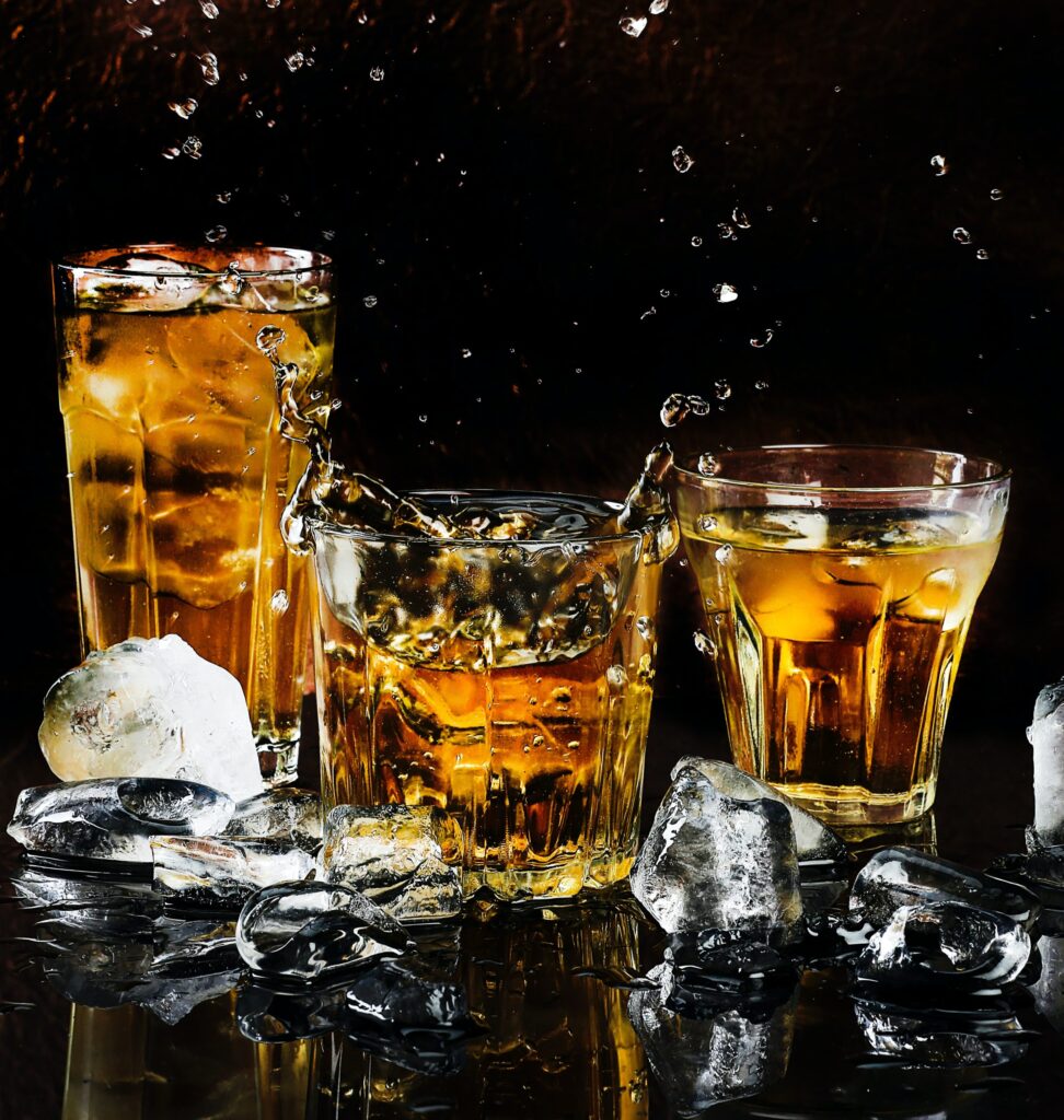 Three cocktail glasses with liquor and ice